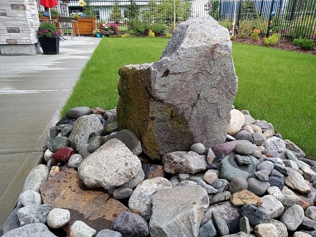 stone water feature lawn bed flowers